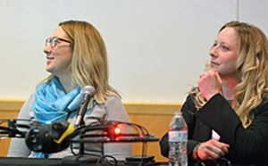 Two women seated at a table as part of a panel discussion